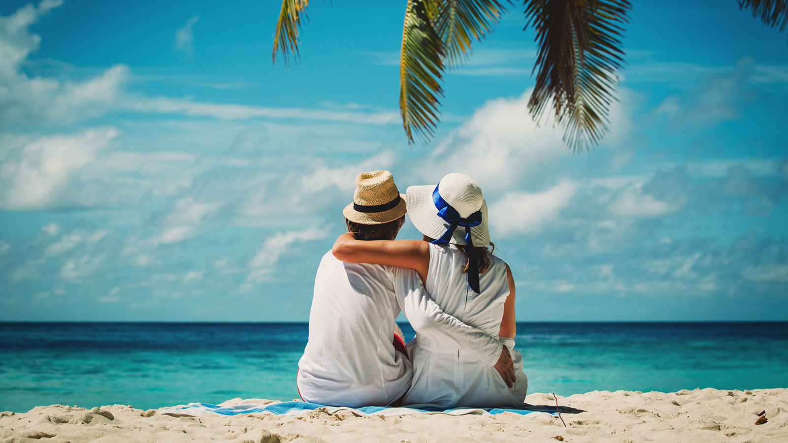 couple sitting on a tropical beach