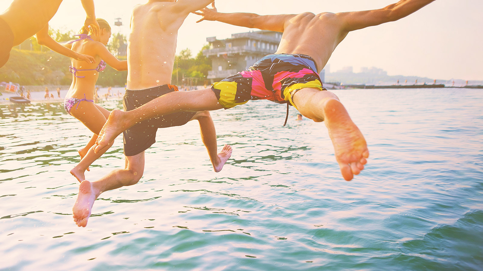 Friends jumping into river