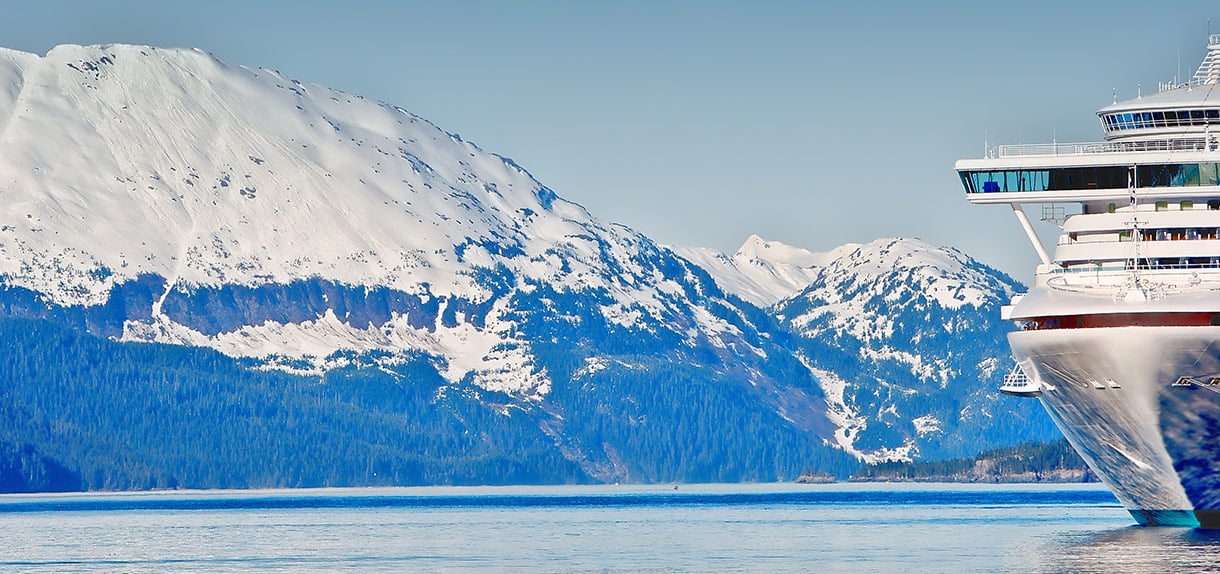 Cruise ship in Alaska with snow-covered mountains.
