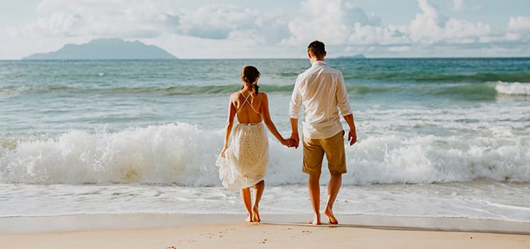 honeymoon wedding couple on beach at sunset